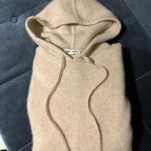 Beige hoodie från Soft Goat - Säljer en supermjuk beige hoodie från Soft Goat. Perfekt för kyliga dagar med sin mysiga huva och långa ärmar. Den har en klassisk design med dragsko i huvan. Nypris 2600kr.                                    Kontakta mig vid frågor