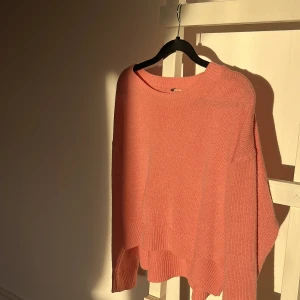 Rosa stickad tröja - Mysig rosa stickad tröja med långa ärmar och ribbade kanter. Perfekt för små kyliga dagar och ger en avslappnad look.