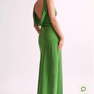Grön långklänning med öppen rygg - Oanvänd klänning:Elegant grön långklänning i ett mjukt och glänsande material. Klänningen har en djup v-ringning och en vacker öppen rygg som ger en sofistikerad look. Perfekt för speciella tillfällen.