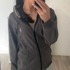 Mörkgrå hoodie från Ralph Lauren - Säljer en snygg mörkgrå hoodie från Ralph Lauren med dragkedja och huva. Aldrig använd så är helt nyskick. 🖤
