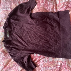Vinröd kortärmad tröja från Oasis - Säljer en vinröd tröja från Oasis med korta ärmar och ett diskret mönster. Perfekt för en stilren look. Tröjan har en ribbad kant vid halsen och ärmarna, materialet är supermjukt! Färgen är lite vinröd med en lila ton💗perfekt nu för lite kallare väder!