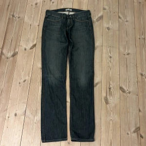 Blå jeans från Acne Jeans - Snygga blå jeans från Acne Jeans i modellen Max/Shaved. De har en klassisk straight/slim passform med fem fickor och orange sömmar. Perfekta för en stilren look.