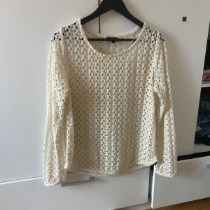 Vit spetsblus - Säljer en elegant vit spetsblus med långärmad design. Perfekt för en stilren och chic look. Blusen har ett vackert mönster och är lätt att matcha med olika outfits.