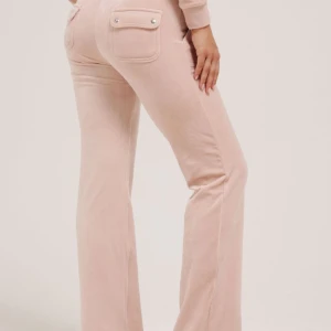 Ljus rosa juicy byxor - Snygga rosa juice byxor med fickor och knappdetaljer bak. Byxorna är perfekta för en mysig hemma dag men även lite finare mjukis byxor❤️ dem har varit använda någon gång  