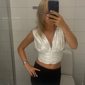 Silvrig fest topp - Superfin fest topp med öppen rygg som tyvärr inte kommer till användning då den är för liten💗Därför använd fåtal gånger och i bra skick. Köpt från gina tricot men tror inte den säljs längre. Skriv för frågor eller fler bilder!!☺️☺️