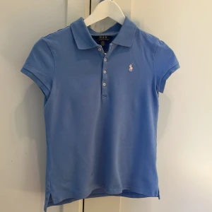 Ljusblå piké från Ralph Lauren - Ljusblå piké från Ralph Lauren Storlek: 12-14 år Fint skick Djur och rökfritt hem