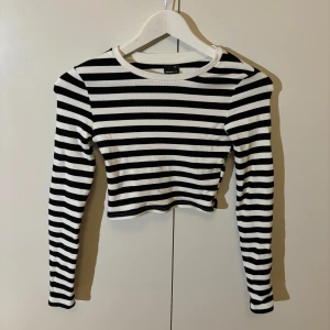 Randig långärmad tröja  - Svart vit randig långärmad tröja från Gina Tricot. Croppad, tajt och storlek xs, normal i storleken. Fint skick, bara använd några fåtal gånger så inga fläckar eller hål.