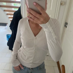 Kofta - Kofta med knappdetaljer på armen.