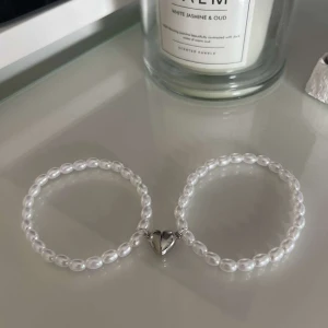 Egengjorda pärlarmband  - Två stycken egengjorda pärlarmband med ett varsit halvt hjärta som kan sättas ihop. 