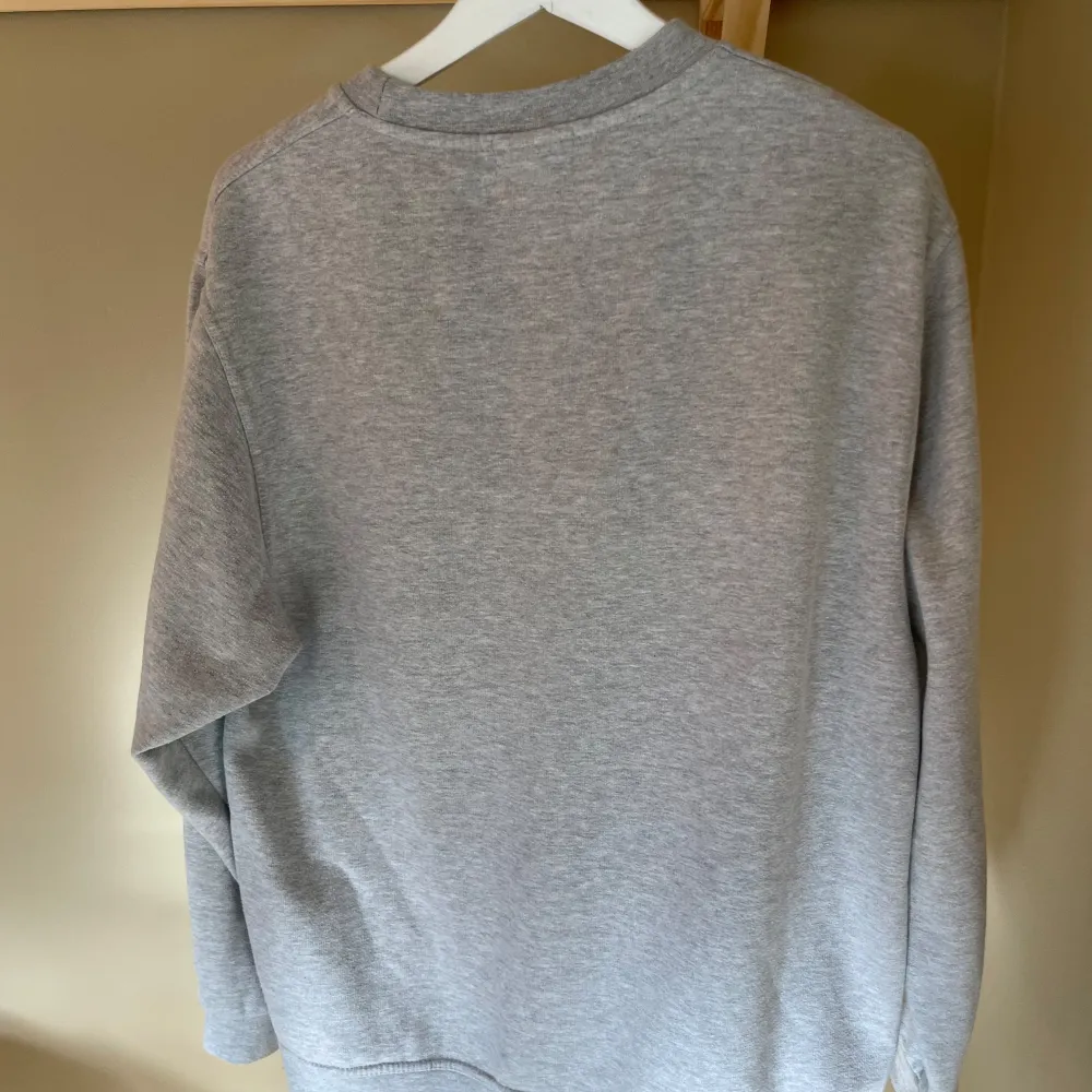 Säljer en grå sweatshirt med texten 'WORLDWIDE SINCE 2013' tryckt i lila på framsidan. Tröjan är i ett mjukt och bekvämt material, perfekt för vardagsbruk. Den har långa ärmar och en klassisk rund halsringning. Passar både tjej å kille. Skick 7/10. Tröjor & Koftor.