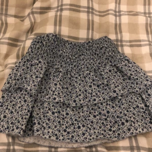 Mörk/ljusblå blommig kjol från Ginatricot!  - Strl, 134/140. Själv så har jag strl 146 i kläder. Men kjolen passar perfekt.💕🌟