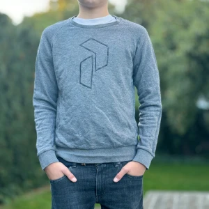 Grå tröja från Peak Performance - Säljer en snygg grå tröja från Peak Performance. Tröjan är i bra skick och superbekväm att ha på sig. Passar perfekt till jeans eller träningsbyxor! Skriv privat för intresse om fler bilder. Skick 7.5/10