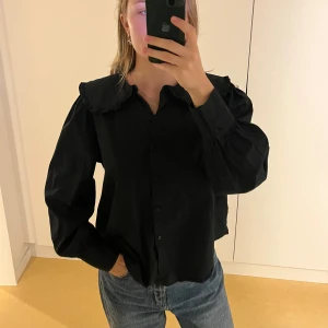 Svart blus - Jättefin svart blus med volangkrage. Köpt på en vintage butik i Italien, därav är märket okänt. Fint skick!!