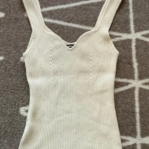 Beige ribbad klänning från Gina Tricot - Säljer en superfin topp från Gina Tricot. Den har en snygg v-ringad design. 