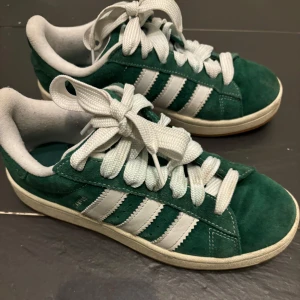 Adidas campus - Mörkgröna campus i strl 38 och 2/3. Ca ett halvår gamla. Använda en del men fortfarande i fint skick. Skickar med två par gröna skosnören som jag fick vid köpet :)  Inköpspris: 1349kr