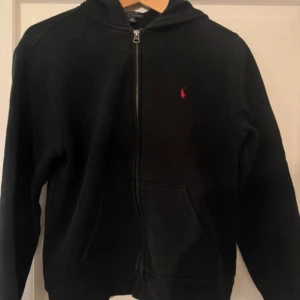 Ralph Lauren zip hoodie - Intressekoll på denna riktigt snygga Ralph Lauren zippen. Tröjan är i bra skick och i storlek 14 - 16 / Large i barnstorlek. Kom med pris du skulle kunna betala för denna och var inte rädd för att skriva frågor.