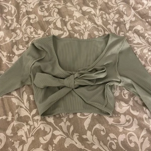 Croppad topp med knytning - Croppad topp med knytning från Shein i storlek xsmall. Går att ta bort snöret för att få en mer basic tröja. Fin ljusgrön färg, bekväm! 