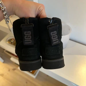 Svarta boots från UGG - Säljer ett par svarta UGG boots i storlek 37. De är i mocka och har en bekväm passform med en robust sula. Perfekta för höst och vinter, håller fötterna varma och stiliga. Dom är i super bra skick!