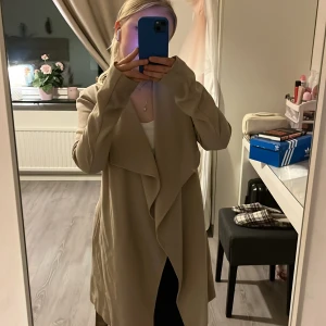 Lång beige kappa - Lång beige tunn kappa perfekt till våren när det börjar bli lite varmare!