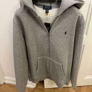 Grå hoodie från Polo Ralph Lauren - Säljer en snygg och bekväm grå hoodie från Polo Ralph Lauren. Helt ny med tag på. Väldigt fet nu för kyliga dagar🔥