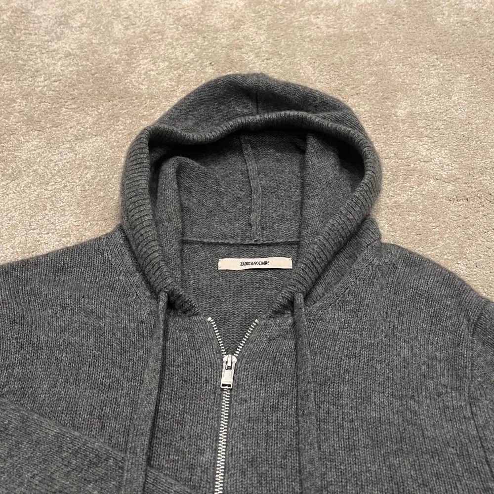 Snygg grå Zip-Hoodie från Zadig & Voltaire. Den är 100% Kashmir och väldigt bekväm. Den är endast använd 3-5 gånger och är därför i perfekt skick utan defekter. Köptes från deras hemsida i vintras. Nypris: ~5500kr. Köparen står för frakten. Storlek S. Hoodies.