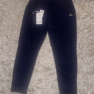 Mörkblåa lacoste byxor - Mörkblåa Lacoste byxor, storlek S, i nytt skick (aldrig använt) och bästa material, skriv om ni har frågor