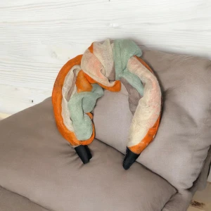 Färgglatt diadem med randigt mönster - Unikt diadem med ett färgglatt randigt mönster i orange, grönt och beige. Perfekt för att ge en färgklick till din outfit. Diademet har en mjuk och bekväm passform.