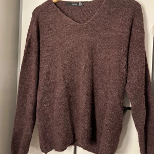 Vinröd stickad tröja från Vero Moda - Mysig vinröd stickad tröja från Vero Moda i storlek XS. Tröjan har en v-ringad hals och långa ärmar, perfekt för kyligare dagar. Den är enkel och stilren, vilket gör den lätt att matcha med olika outfits.