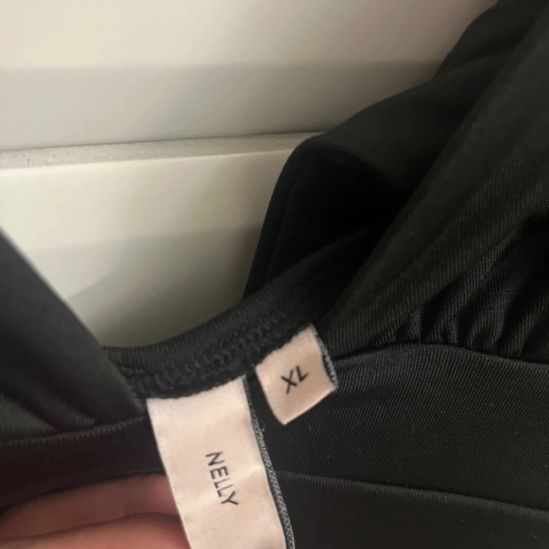 Svart topp med knytdetalj på baksidan av tröjan från Nelly - 2