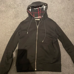 Svart huvtröja från Burberry - Tja! Säljer denna stilrena svarta huvtröjan från Burberry! Det är ett bra skick! Storlek M men passar även S. Pris kan diskuteras vid snabbt köp. Så hör av dig för mer information eller bilder.