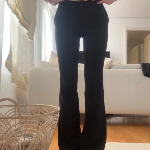 Svarta low waist bootcut kostymbyxor - Från design by si. Storlek S med extra långa ben. Skulle dock säga att de är mer som xs-s då de är små på mig som normalt har S. Jag är 180cm lång (på bilden) och brukar ha 85cm innerbenslängd. Dessa är på gränsen till för långa. De ska enligt hemsidan vara low waist men de är mer mid waist enligt mig