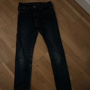 Mörkblå slim jeans - Snygga mörkblå jeans med en klassisk femficksdesign och knappgylf. Perfekta för en avslappnad stil med en smal passform som ger en modern look. Säljer då de är lite små och inte används!