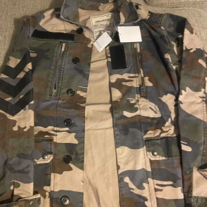 Camouflagejacka från Zadig & Voltaire - Snygg camouflagejacka från Zadig & Voltaire med knappar och dragkedja. Köpt xs men stor i storlek så passar S (Helt ny) ny pris ligger på 4000 säg till vid minsta fundering. Priset går att diskuteras