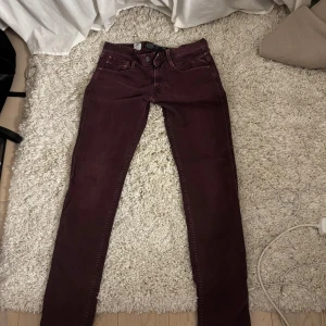 Vinröda jeans från Replay - Snygga vinröda jeans från Replay med en lite mer skum passform (inte skinny)! Köpta från sellpy och helt oanvända pga fel storlek!