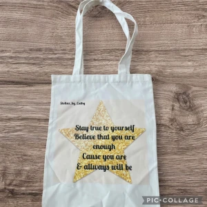 Vit shoppingväska med stjärndesign - Vit shoppingväska med ett stort gult stjärnmotiv och inspirerande text. Perfekt för att bära med sig vardagliga saker med stil. Tillverkad i ett lätt och hållbart material med bekväma handtag.