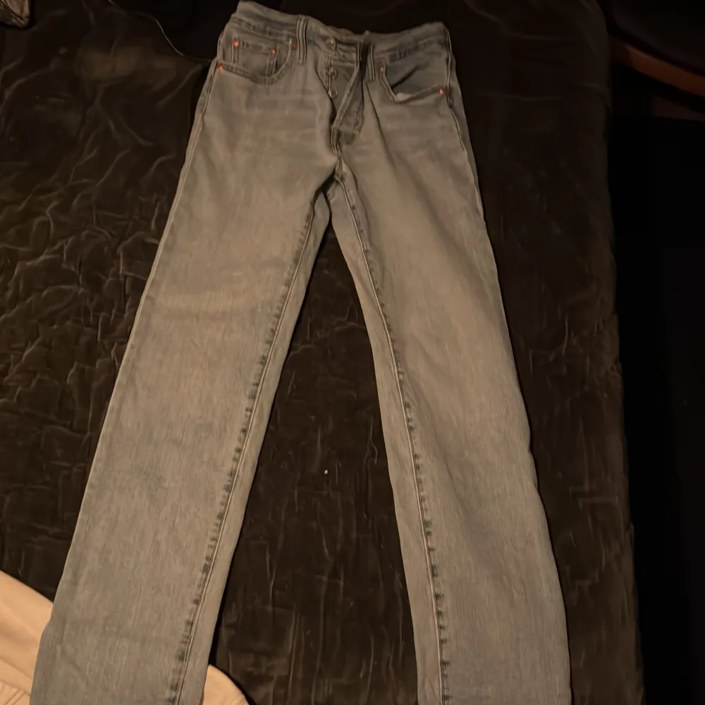 Säljer ett par klassiska ljusblå Levi's 501 jeans. De har en straight passform och är tillverkade i slitstarkt denim. Perfekta för en avslappnad stil. Jeansens ikoniska design inkluderar knappgylf och fem fickor.. Farkut & Housut.