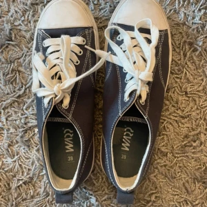Blåa sneakers från Warp - Snygga mörkblåa sneakers från Warp med vita detaljer och snörning. Perfekta för en avslappnad stil. Skorna har en klassisk design med vit sula och tåhätta.
