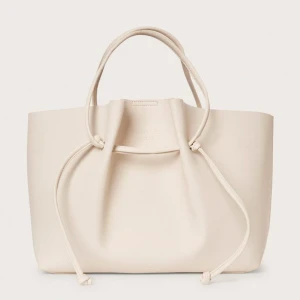 Beige handväska från Stockholm Studio - Snygg beige handväska från Stockh lm i skinn. Väskan har en stilren design och är jätte rymlig och smidig då man kan ändra ”storlek” med hjälp av att justera banden! Har lite fläckar på insidan men ser i princip helt ny ut utifrån! Skriv vid frågor🥰