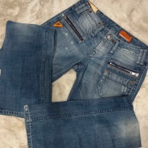 Blå jeans med dragkedjedetaljer - Snygga bootcut lågmidjade jeans. Skriv privat för mått. Säljer för att de är för små. 
