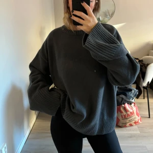 Mörkgrå stickad kaschmir tröja - Säljer en mysig mörkgrå stickad tröja med långa ärmar och ribbade muddar. Perfekt för kyliga dagar och ger en avslappnad look. Passar bra till både jeans och leggings. Endast testad, nypris 1300. Har vanligtvis xs/s tog L för ville ha den stor