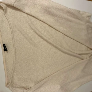 Beige stickad tröja från Gina Tricot - Säljer en stilren beige stickad tröja från Gina Tricot. Perfekt för en avslappnad look med sin mjuka och bekväma passform. Tröjan har en enkel design som gör den lätt att matcha med olika outfits. den har en båtneck och super snyggt