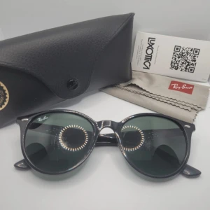 Svarta solglasögon från Ray-Ban - Snygga svarta solglasögon från Ray-Ban med rund form och mörka linser. Kommer med ett stilrent svart fodral och putsduk. 