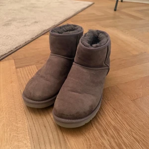 Grå boots från UGG - Säljer ett par gråa boots från UGG. De är tillverkade i mocka med en mjuk och varm insida. Storlek 43 