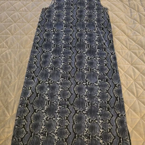 Blå klänning - Snygg blå klänning med en liten slits på sidan. Klänningen är ärmlös och har en ribbad struktur som ger en cool look. Perfekt för att sticka ut med stil!