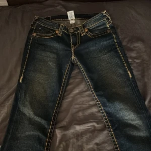 Lågmidjade  true religon jeans  - Snygga mörkblå jeans från True Religion med kontrastsömmar med snygg ficksdesign. Är i storlek 29 i jeans och midjemått är 38 rakt över 💘