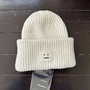 Acne mössa - Beige stickad mössa från Acne Studios. Använt några gånger så läppen är inte kvar. Säljer då den inte kommer till så mycket användning.