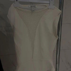 Festlig Body - En festligare body från Nelly med en nät- v-ringning. Finns inte kvar på Nelly vad jag vet. Liten defekt på baksida, rygg som man ser på bild nr 2. Storlek S. Pågrund av skada vid rygg så sänks priset! 