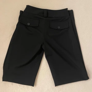 Kostymbyxor  - Svarta kostymbyxor från Gina i strl XS. Fakefickor baktill