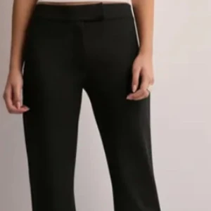 Svarta kostymbyxor - Eleganta svarta tighta kostymbyxor med hög midja och bootcut-stil. I strl S