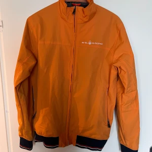 Orange jacka från Sail Racing - Säljer en snygg orange jacka från Sail Racing i storlek medium. Använd ett fåtal gånger så i nästan ny skick har du någon fråga så är de bara att ställa Ny pris 2200kr  mvh Assar 